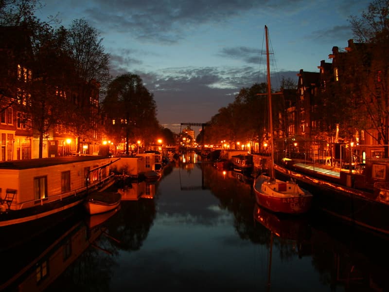 Fotografia del quartiere Jordaan di Amsterdam di notte con al centro un canale che attraversa la città