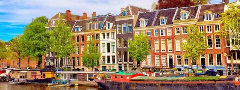 Fotografia di alcuni edifici di Amsterdam in riva ad un canale in estate