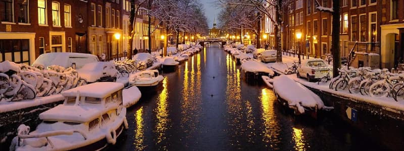 Fotografia di un canale di Amsterdam con le navi attraccate sui lati ricoperte dalla neve in inverno