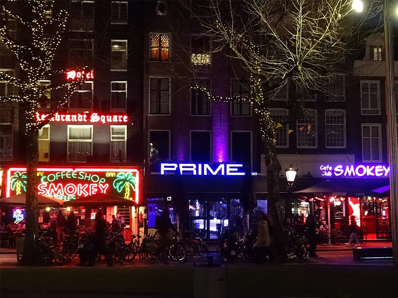 Fotografia di un angolo del quartiere Rembrandtplein di Amsterdam di notte con le insegne dei locali accese