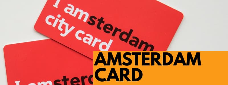 Fotografia di 2 Amsterdam Card, 2 tessere rosse con scritte bianche e nere su sfondo bianco con rettangolo arancione in basso a destra Amsterdam Card