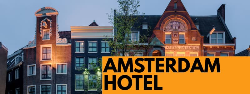 Fotografia di un hotel ad Amsterdam di sera dall'esterno con le luci accese ed un rettangolo arancione in basso a destra con scritta nera Amsterdam Hotel