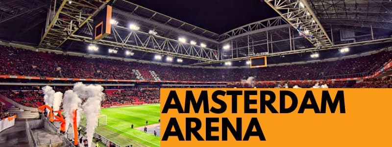 Fotografia dello stadio di calcio Amsterdam Arena durante una partita con rettangolo arancione in basso a destra con scritta nera "AMSTERDAM ARENA"